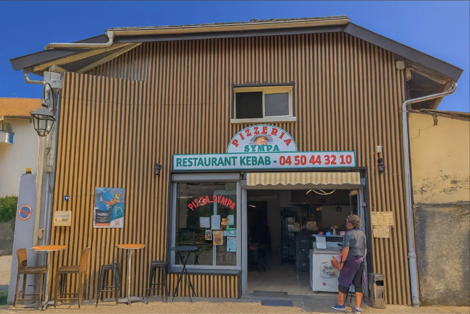 La devanture de Pizza Sympa, rue de la Poste à Doussard, avec son enseigne et son numéro de téléphone